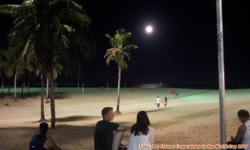Turistas e visitantes contemplam o luar na praia de Copacabana