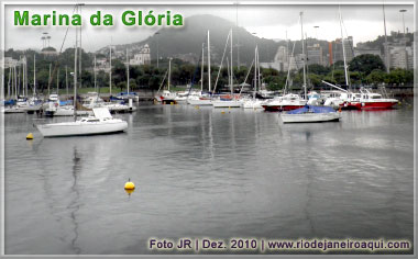 Barcos ancorados v&atilde;o ficando para tr&aacute;s, tendo ao fundo o Outeiro da Gl&oacute;ria