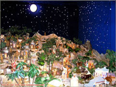 Presépio de Natal com peças e miniatura sob representação de céu estrelado Presépio de Natal com peças e miniatura sob representação de céu estrelado